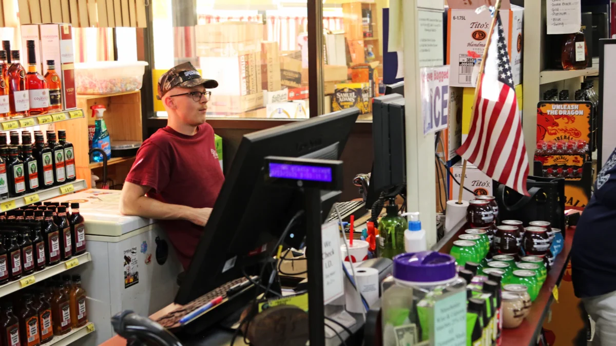 Shop owner at the checkout counter of a small store