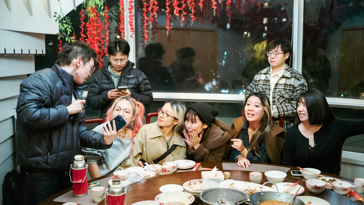 Friends sharing a festive meal at a restaurant with lanterns