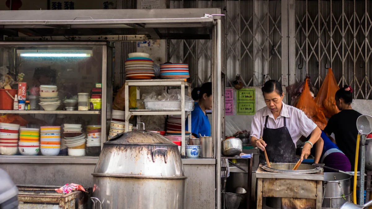 Hawker stall owner cooking at a traditional food stall