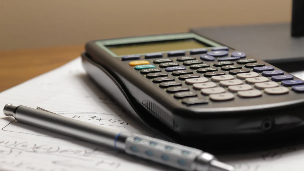 Calculator and pen on paperwork for budgeting