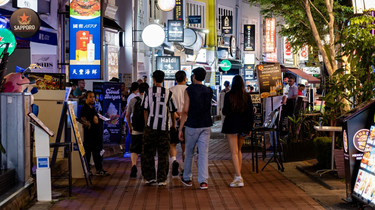 Diners and restaurants along a riverside street at night