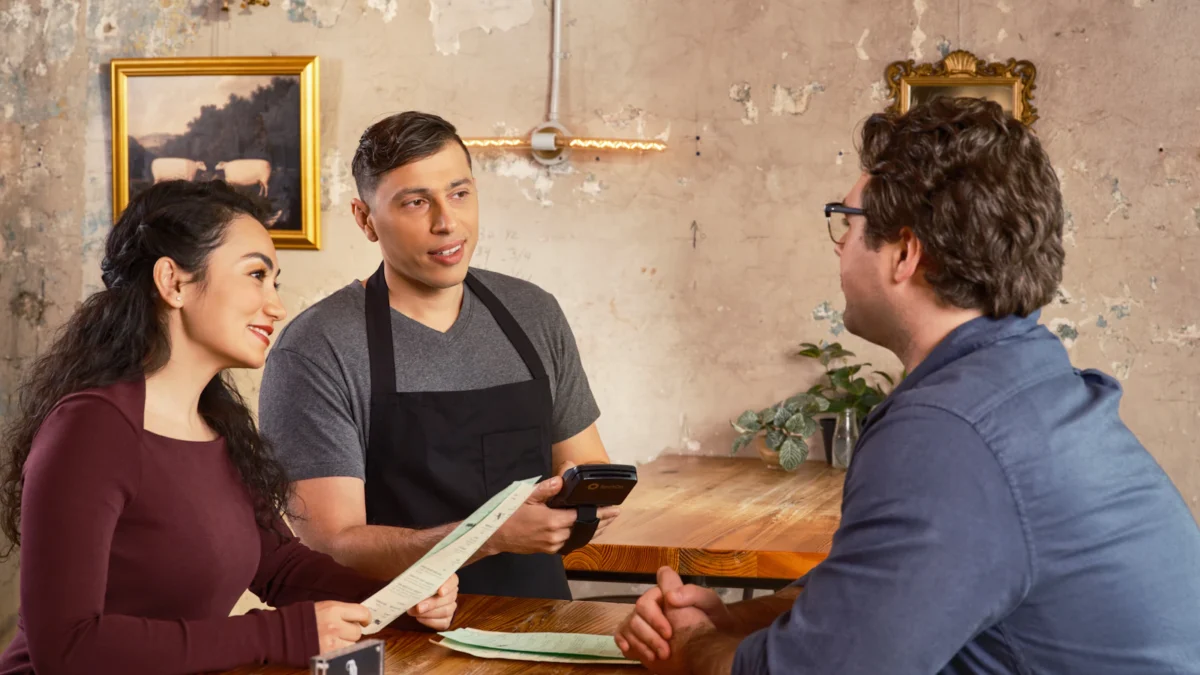 Restaurant manager talking with diners at their table